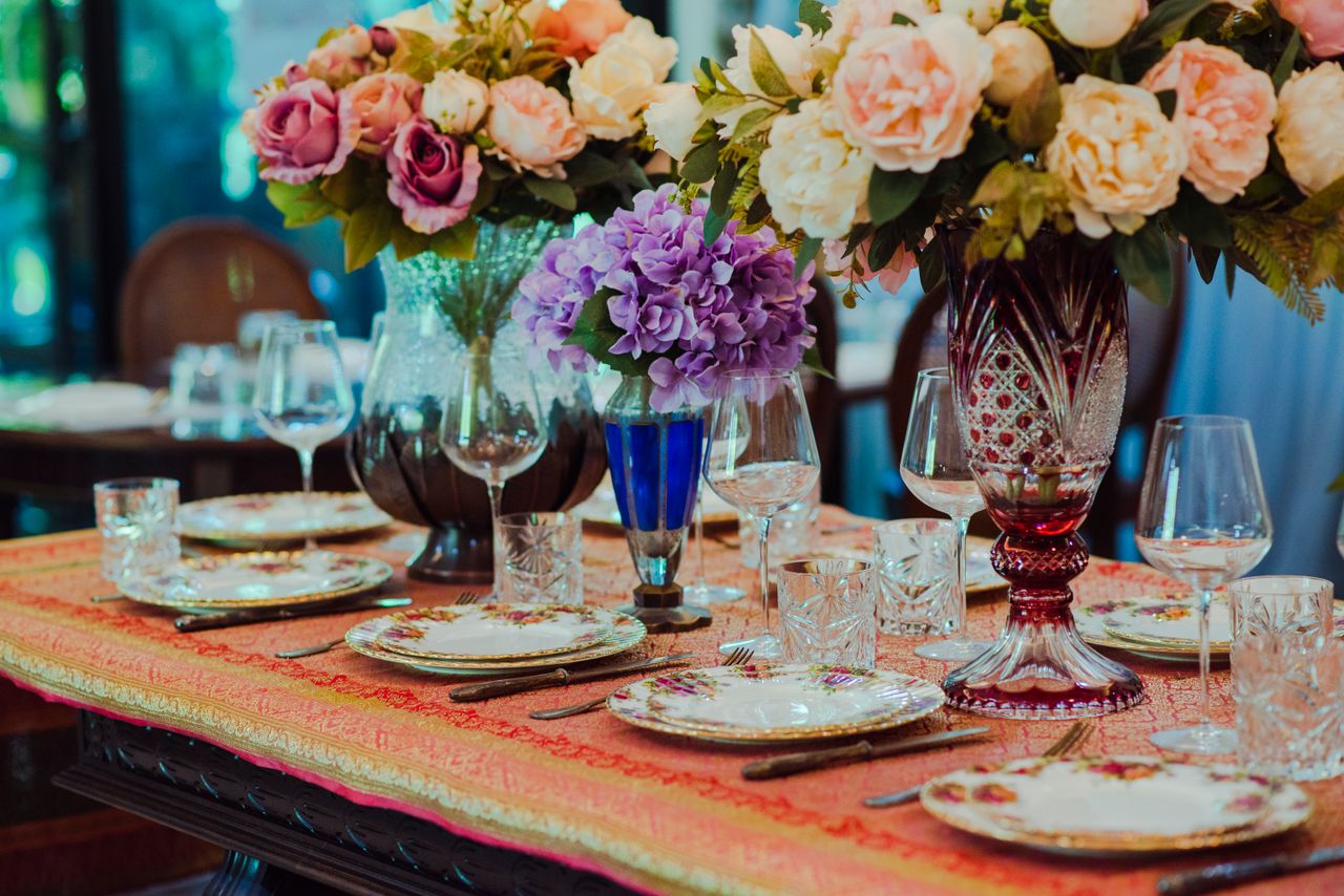 Home Elegant floral tablescape featuring vintage tableware, vibrant flower arrangements, and crystal glassware.