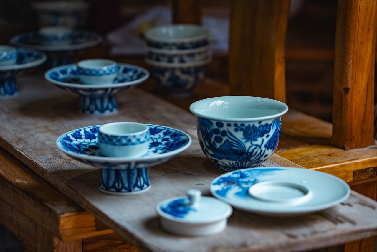 Home Elegant blue and white porcelain tableware set on a rustic wooden table indoors.